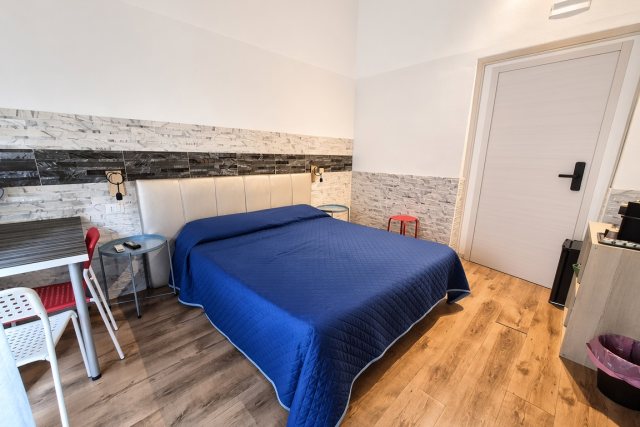 La camera T-Premium vista di lato, con il letto e la porta del bagno privato